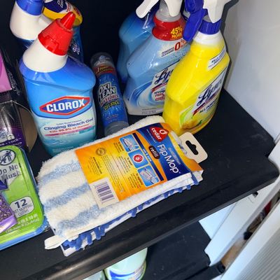 Assorted household cleaning supplies including Lysol spray, Clorox toilet bowl cleaner, OxiClean gel stick, and an O-Cedar Flip Mop...