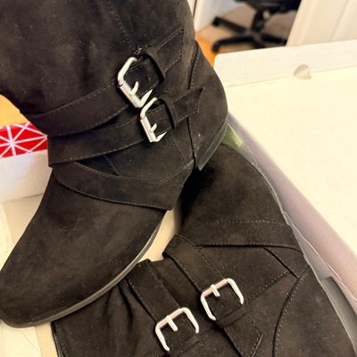 Pair of women's black suede ankle boots featuring double silver buckle strap accents.