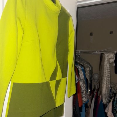 Vintage 1960s-style mod tunic top featuring a high neckline and geometric color-blocked pattern in lime yellow and olive green.