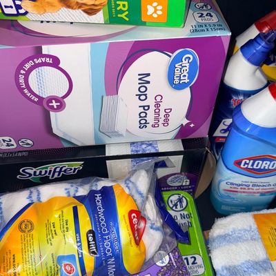 Assortment of modern household cleaning supplies, including Swiffer and Great Value mop refill pads, O-Cedar microfiber mop refills, and...