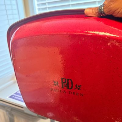 Paula Deen red speckled enamel roasting pan or casserole dish bottom featuring black logo detail.