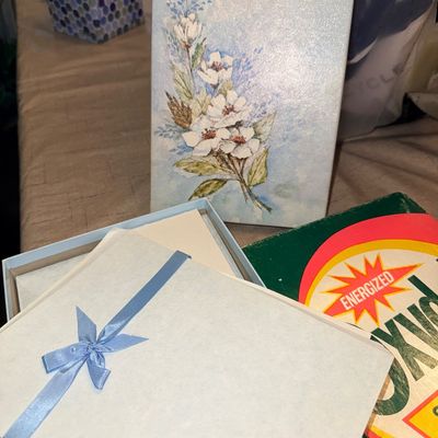 Vintage stationary set featuring a floral bouquet illustration and ribbon-bound paper, displayed alongside a box of Oxydol detergent.