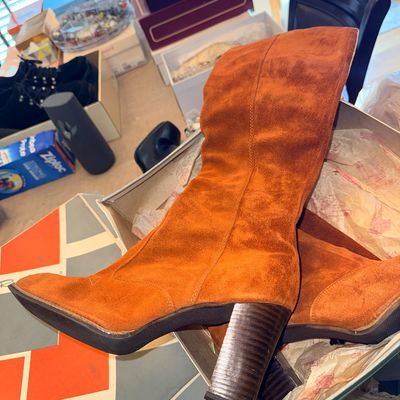 Vintage 1970s Revelations orange suede knee-high boots with stacked block heels, resting in their original box.