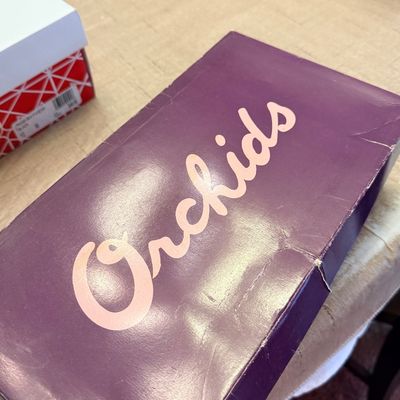 Vintage purple Orchids brand shoebox showing light wear along the edges.