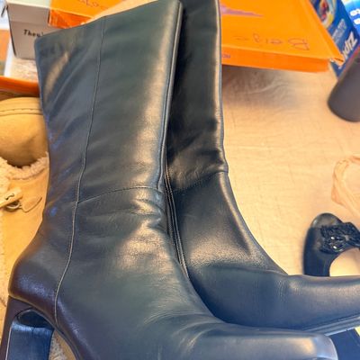 Pair of women's black leather knee-high boots featuring square toes and block heels.