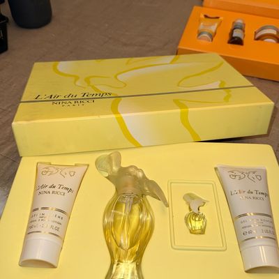 Vintage Nina Ricci L'Air du Temps fragrance gift set in its original yellow presentation box, featuring a full-size dove stopper...