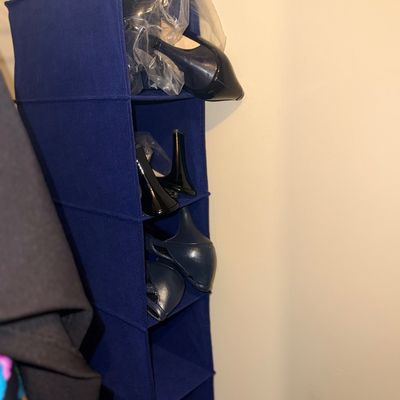 Blue fabric hanging closet shoe organizer filled with women's dress shoes and heels.