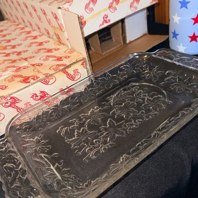 Vintage rectangular clear press-glass serving tray featuring an embossed poinsettia floral design with integrated side handles.