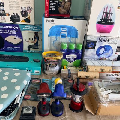 Collection of boxed household items, small appliances, and gadgets, including a HoMedics foot spa, Lilumia makeup brush cleaner, Bavarian...