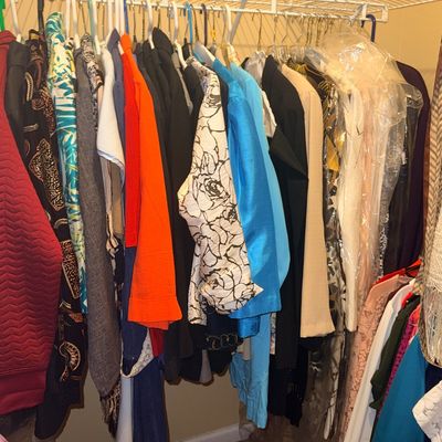 Closet filled with women's vintage and contemporary plus size clothing, featuring a variety of colorful jackets, blouses, dresses,...
