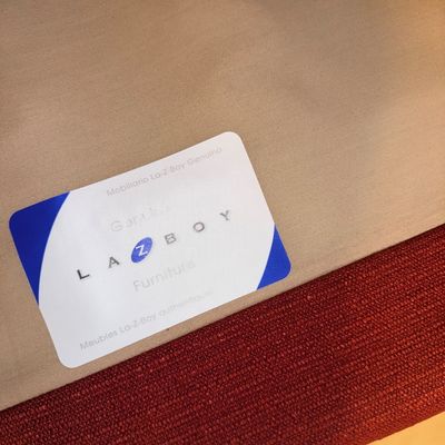 Genuine La-Z-Boy Furniture manufacturer tag attached to a red upholstered piece of furniture.