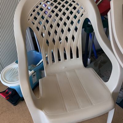 Off-white plastic outdoor patio armchair featuring a lattice-pattern backrest.