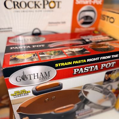 Gotham Steel Pasta Pot and Crock-Pot Smart-Pot slow cooker, both in their original retail packaging.