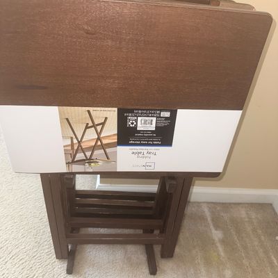 Set of contemporary Mainstays dark wood folding TV tray tables on a matching storage stand with original retail label.