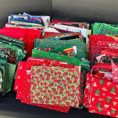 Sale Photo Thumbnail #60: Large assortment of Christmas-themed quilting fabric quarters and scraps in various red and green holiday patterns.
