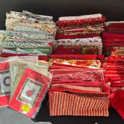 Sale Photo Thumbnail #46: Large assortment of quilting fabric quarters and patterns, featuring a variety of red, green, and holiday-themed prints alongside several Quilter's Magazine issues.
