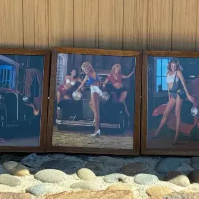 Sale Photo Thumbnail #75: Set of five framed vintage pin-up style prints featuring models posing with classic hot rods and trucks, housed in matching wooden frames.