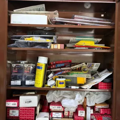 Sale Photo Thumbnail #148: A brown metal storage cabinet filled with various tools and hardware, including Starrett layout dye, MagJig magnetic clamps, and boxed precision instruments.