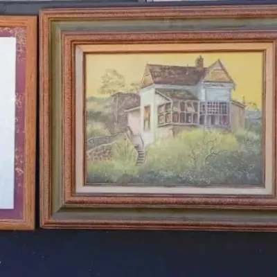 Sale Photo Thumbnail #183: Three framed artworks, including a colorful floral print, a painted landscape of a house on a hill, and a whimsical illustration of cats on a fence.