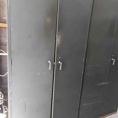 Sale Photo Thumbnail #136: Vintage industrial metal storage cabinets in dark green, showing some surface wear and scratches.