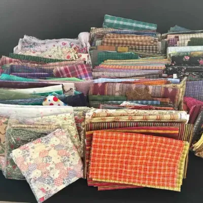 Sale Photo Thumbnail #53: Large assortment of quilting fabric remnants in various patterns, including plaids, stripes, and florals, accompanied by a "Plaids & Stripes" quilting book.