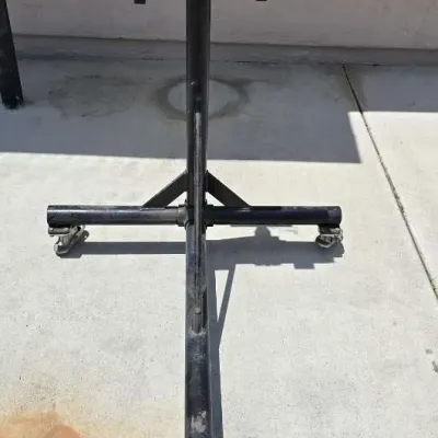 Sale Photo Thumbnail #50: Black metal engine stand on wheels, showing some wear from use.