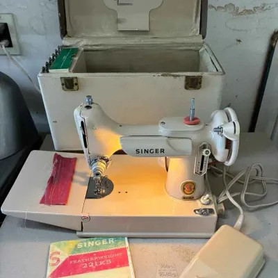 Sale Photo Thumbnail #23: Vintage Singer Featherweight 221K5 sewing machine in white, complete with its original carrying case, foot pedal, and instruction manual.