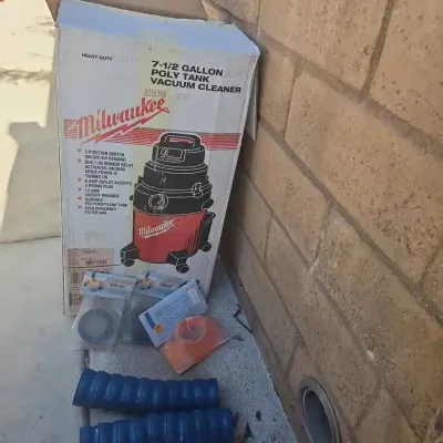 Sale Photo Thumbnail #22: Vintage Milwaukee 7-1/2 gallon poly tank vacuum cleaner in its original box, accompanied by various attachments and hoses.