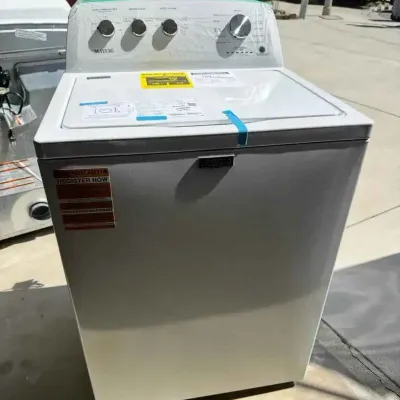 Sale Photo Thumbnail #78: Modern Maytag top-load washing machine in white, appearing in like-new condition with original protective film and stickers still attached.