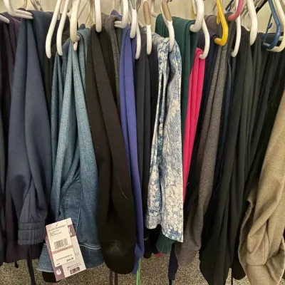 Sale Photo Thumbnail #94: Assorted women's pants and jeans hanging on a clothing rack, including a pair of Gloria Vanderbilt jeans with original tags attached.