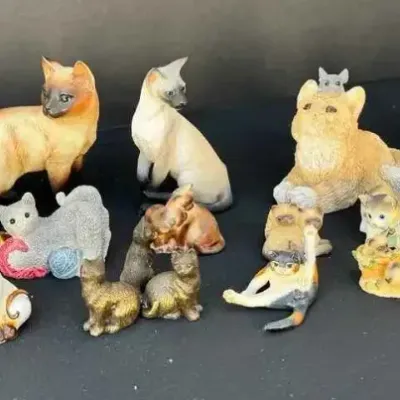 Sale Photo Thumbnail #69: Large collection of vintage ceramic and porcelain cat figurines in various poses, styles, and sizes, featuring Siamese, longhair, and calico designs.