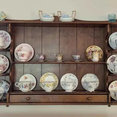 Sale Photo Thumbnail #138: Vintage wooden wall-mounted plate rack and display shelf, shown filled with an assortment of collectible porcelain teacups and saucers.