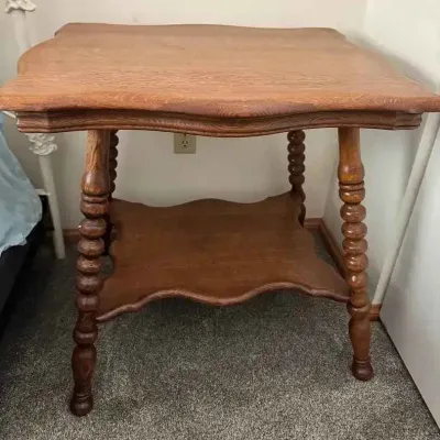 Sale Photo Thumbnail #164: Vintage oak parlor table featuring a scalloped top and lower shelf, supported by turned spool legs.