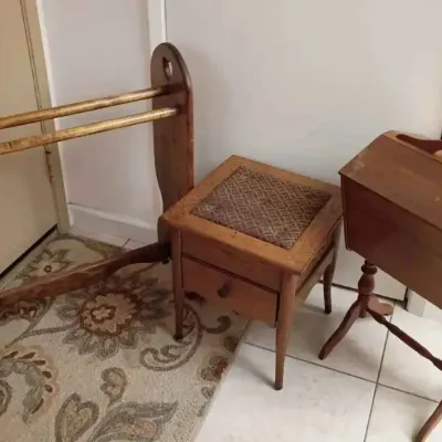 Sale Photo Thumbnail #176: Three vintage wooden furniture pieces, including a quilt rack, a small footstool with a patterned fabric top and drawer, and a standing sewing box with a hinged lid.