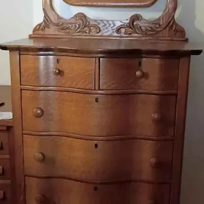 Sale Photo Thumbnail #2: Antique oak serpentine highboy dresser featuring a matching swivel mirror with ornate carved details.