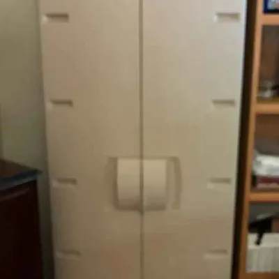 Sale Photo Thumbnail #187: Tall beige plastic storage cabinet with double doors and integrated handles, suitable for utility or garage organization.