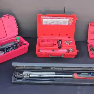 Sale Photo Thumbnail #105: Assorted power tools and hand tools, including a rotary tool kit, a cordless drill kit, and a digital torque wrench in their respective protective carrying cases.