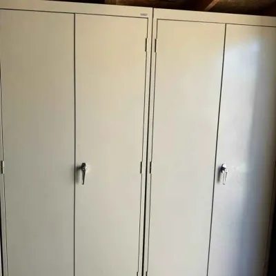 Sale Photo Thumbnail #37: Two heavy-duty beige metal storage cabinets with double doors and locking handles, suitable for garage or workshop organization.