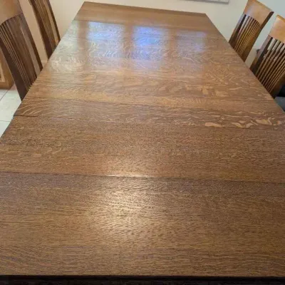 Sale Photo Thumbnail #14: Mission-style quarter-sawn oak dining table with extension leaves, paired with four matching slat-back chairs.