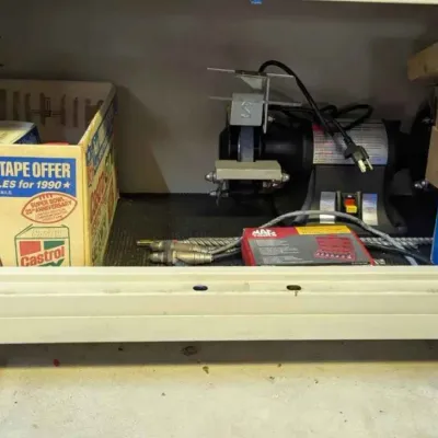 Sale Photo Thumbnail #109: Bench grinder, Mac Tools set, and vintage Castrol GTX cardboard box stored inside a rolling metal cabinet.