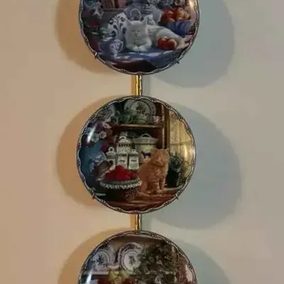 Sale Photo Thumbnail #198: Three-tier brass plate hanger featuring a collection of decorative cat-themed plates.