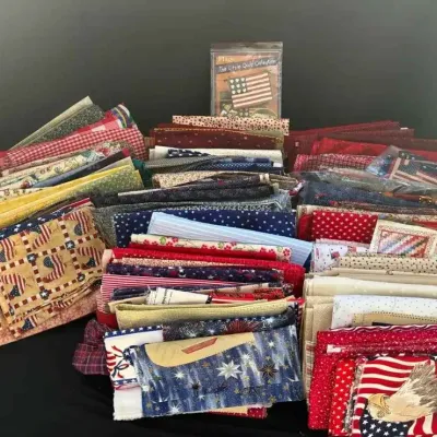 Sale Photo Thumbnail #48: Large collection of quilting fabric quarters and scraps, featuring patriotic American flag and eagle motifs alongside various red, white, and blue patterns.