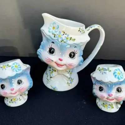 Sale Photo Thumbnail #11: Vintage Lefton ceramic blue cat creamer and matching salt and pepper shakers, featuring hand-painted floral details and bonnets.