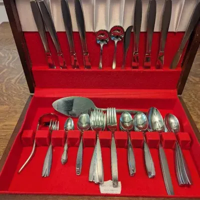 Sale Photo Thumbnail #188: Vintage mid-century modern stainless steel flatware set, presented in a wooden storage chest lined with red felt.