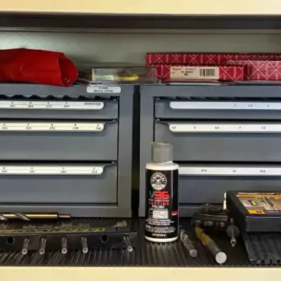Sale Photo Thumbnail #9: Two Huot drill index cabinets filled with drill bits, accompanied by various machining accessories, wooden storage boxes, and a bottle of Chemical Guys V36 optical grade cutting polish.