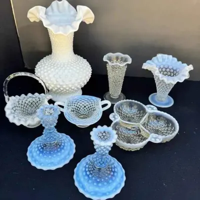 Sale Photo Thumbnail #151: Fenton hobnail milk glass and opalescent glass collection, including a large ruffled vase, candlesticks, baskets, and serving dishes.