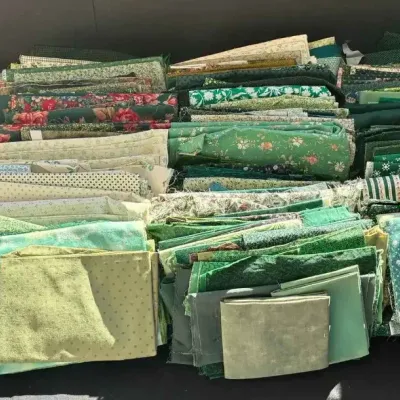 Sale Photo Thumbnail #41: Large collection of green quilting fabric quarters and scraps in various patterns, accompanied by several quilting instruction books.