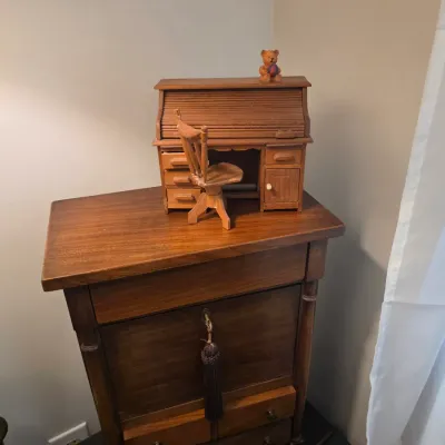 Sale Photo Thumbnail #68: Vintage wooden drop-front secretary desk with lower drawers, topped with a miniature wooden roll-top desk and chair set.