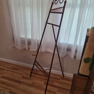 Sale Photo Thumbnail #44: Vintage metal display easel featuring scrollwork at the top and decorative wooden bead accents.