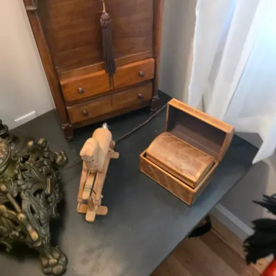 Sale Photo Thumbnail #67: Vintage wooden tabletop items including a small rocking horse figurine, a nested set of wooden boxes, and a miniature wooden chest of drawers with tassel detail.